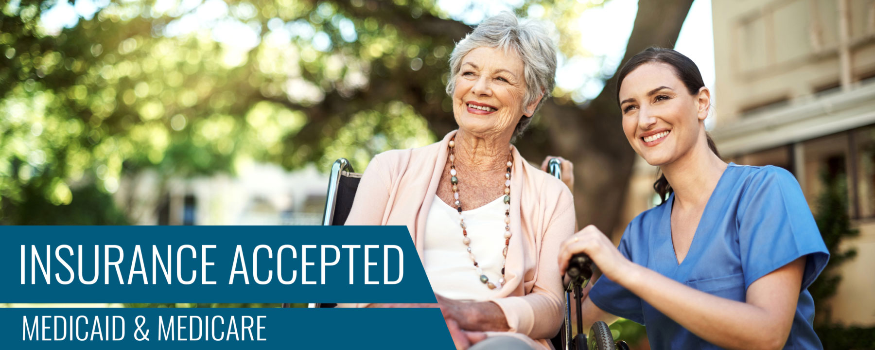 A smiling senior woman in a wheelchair with a smiling female healthcare worker squatting beside are enjoying the views in an outside garden area. The words "Insurance Accepted Medicaid & Medicare" are written on the image.